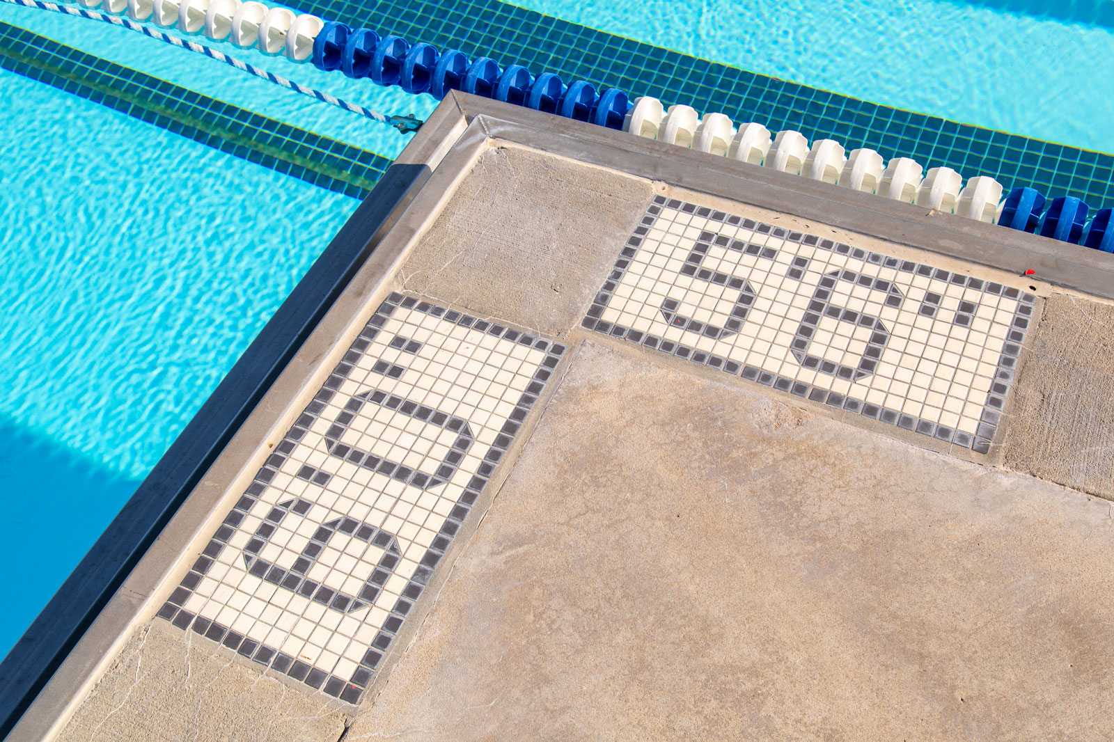 Pool deck with depth markers ‘6’0” and ‘5’6’ — pool safety and depth measurement signage.