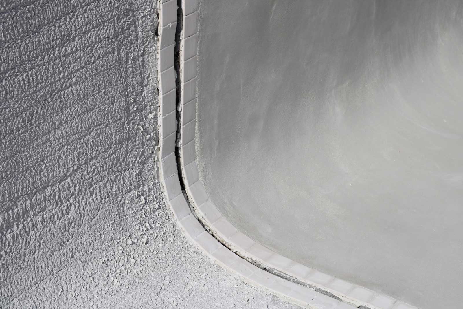 Close-up of pool corner with rough surface — pool resurfacing and concrete repair detail