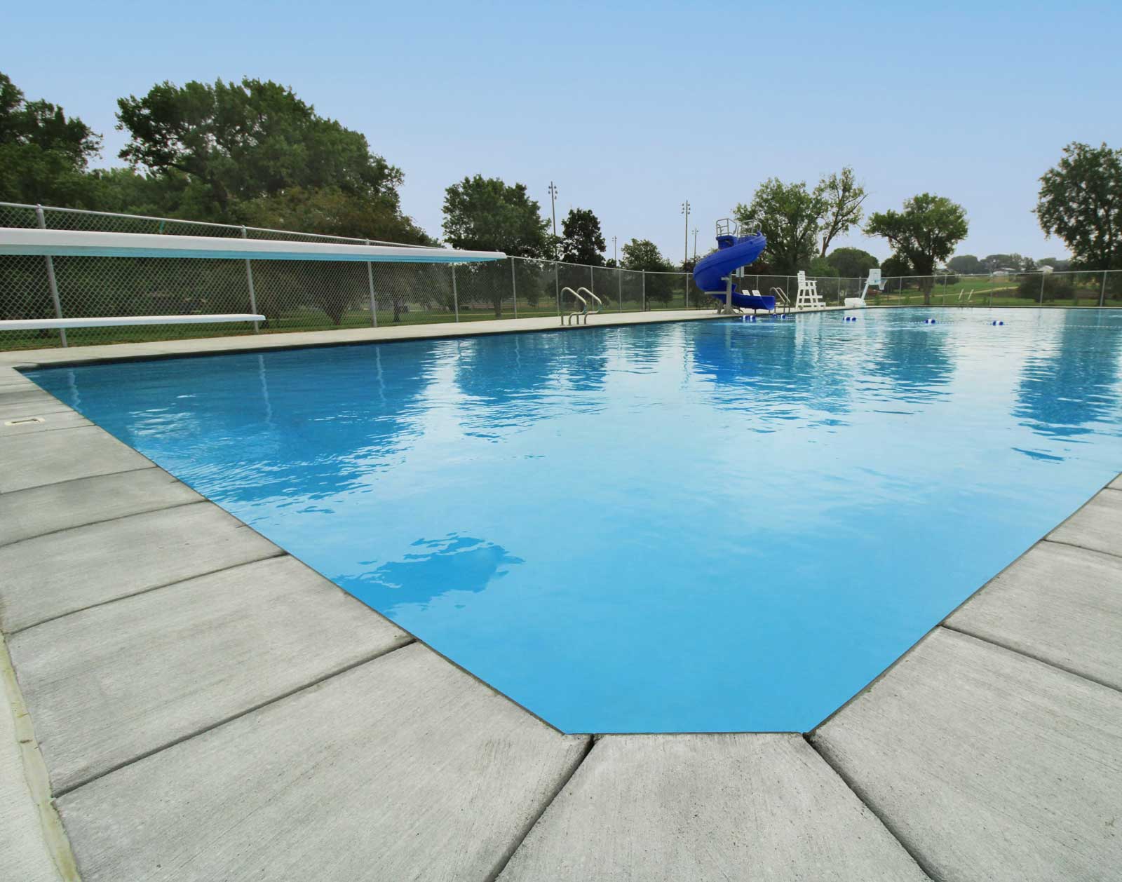 Outdoor swimming pool with slide and lounge chairs — family‑friendly pool design and renovation