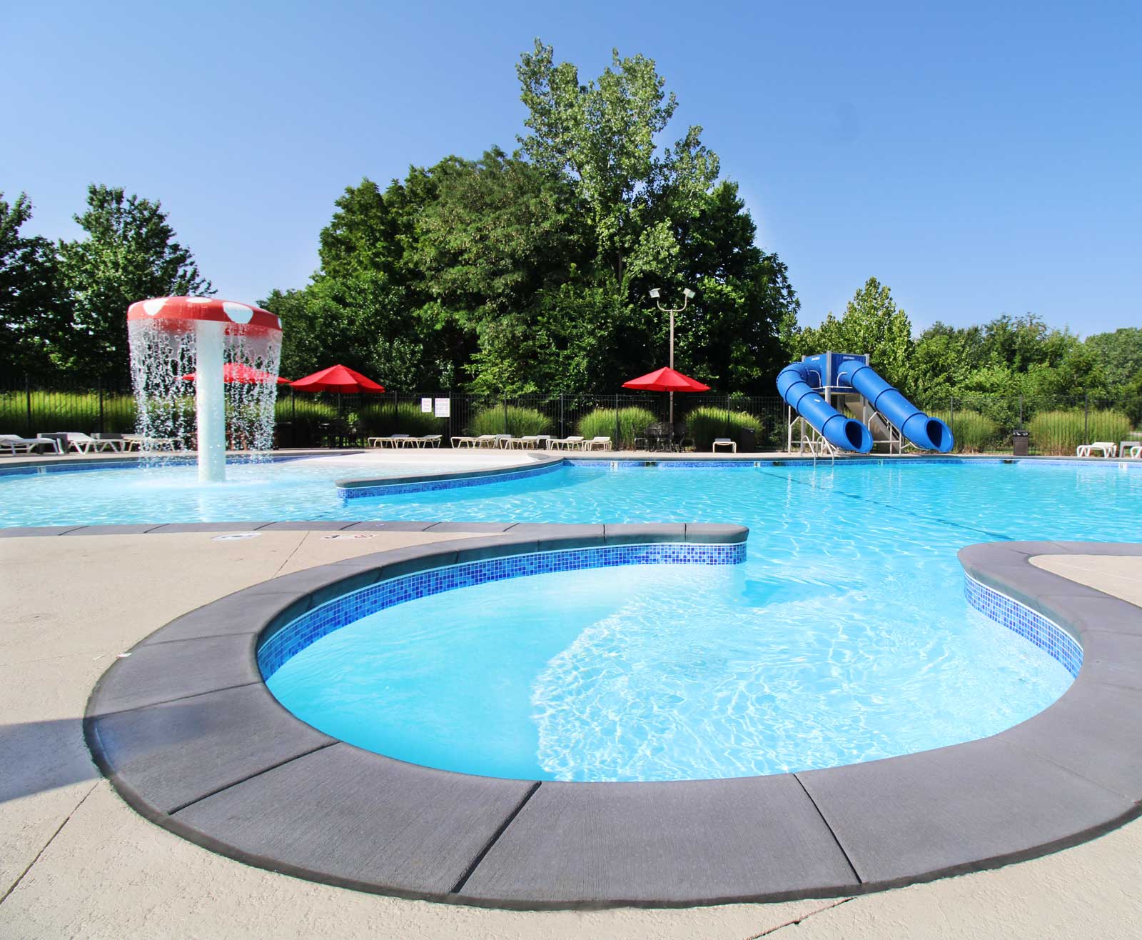 Luxury residential swimming pool with tiled deck — upscale backyard pool renovation inspiration