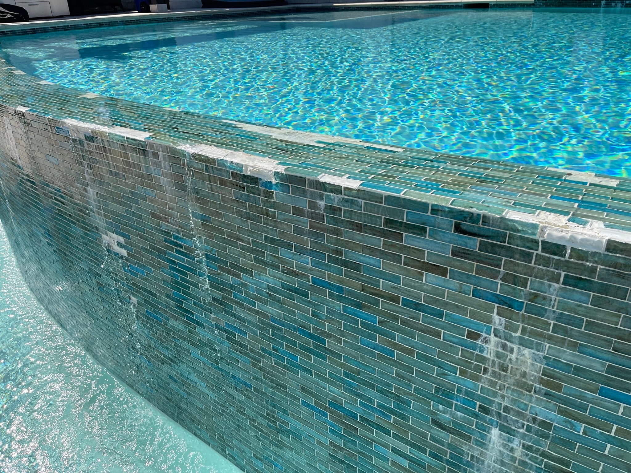 Close-up of a tiled swimming pool with visible mineral deposits